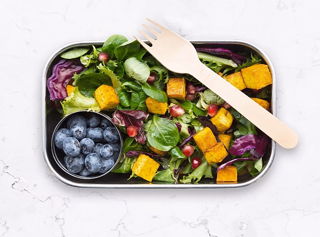 Vibrant grain bowl with greens, tofu, blueberries — flexible, real-food nutrition.